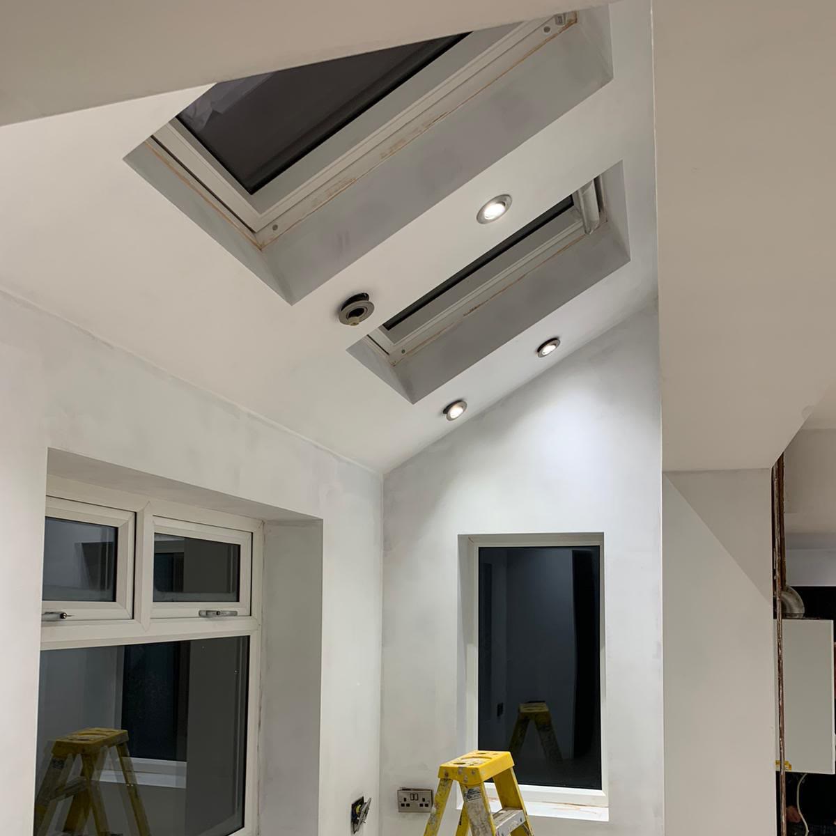Vaulted ceiling with two roof windows and downlights fitted into the slope between them