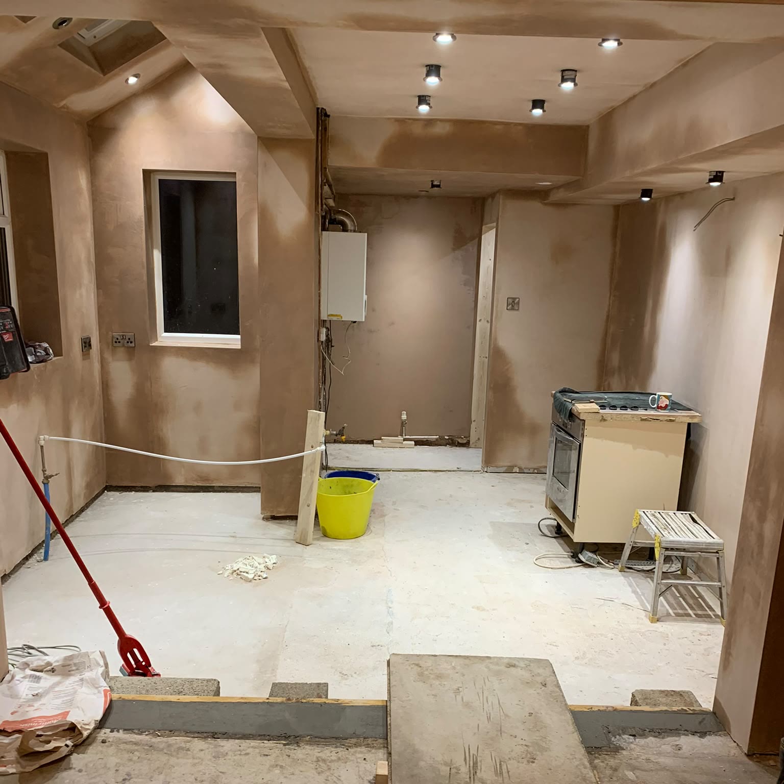 Room at plastering stage with the new downlights and spotlights already installed and switched on