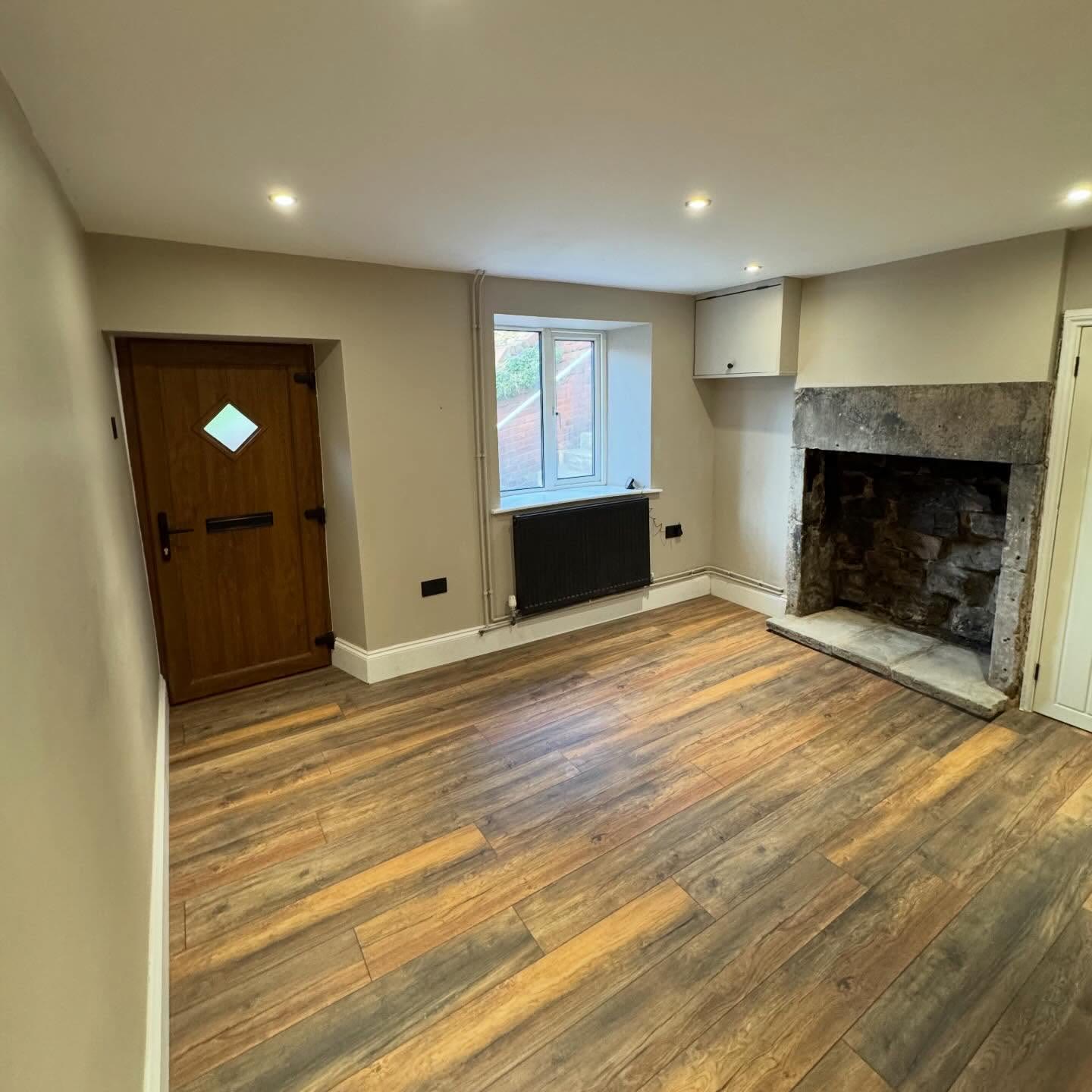 Living room after renovation with downlights set through the ceiling and a restored stone fireplace